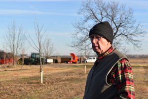 Dr. George Ray McEachern stands in the Texas A&M pecan orchard in January and looks toward Short Course participants behind the camera.