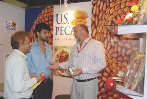 Representing U.S. Pecans, Bruce Caris of Green Valley Pecan Company visits with visitors at the booth.