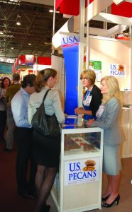 Two visitors stop by at the U.S. Pecans' booth at SIAL Paris to learn about and taste pecans. (Photo by Blair Krebs)