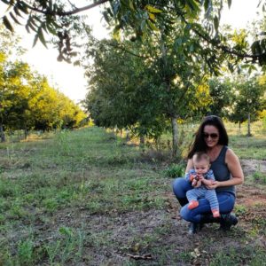 A woman poses with her baby in a pecan grove in Brazil.