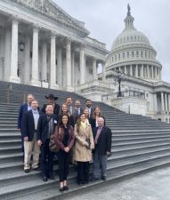 The team representing the National Pecan Federation and the pecan industry stands in front of the Capitol Building on a rainy day for the Walk the Hill event.