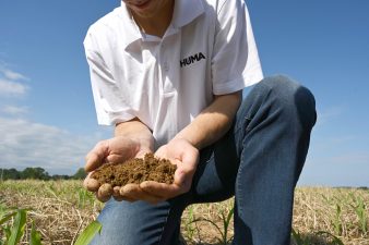 A Huma Agronomist holding and examining soil.
