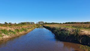 A wide, pristine channel in an agricultural field.